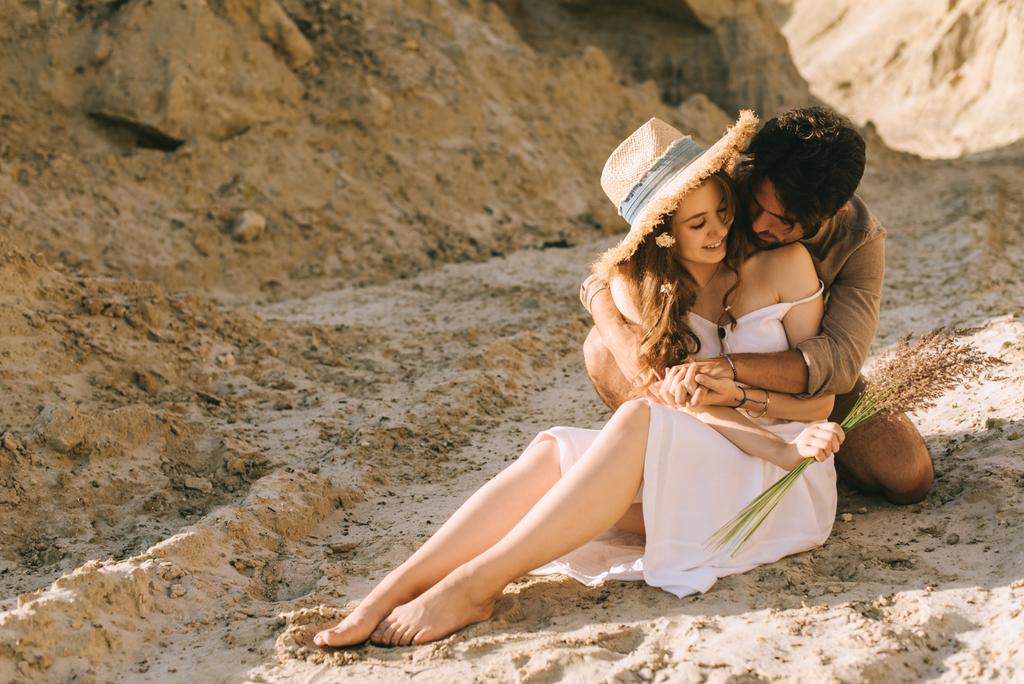 sorrindo jovem casal abraçando no desfiladeiro de areia
 - Foto, Imagem