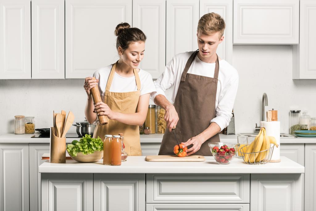 couple cuisine salade et couper les légumes dans la cuisine
  - Photo, image