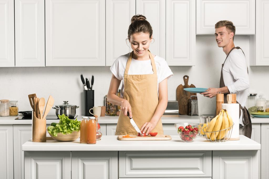 fidanzata cottura insalata e taglio pomodori in cucina
 - Foto, immagini