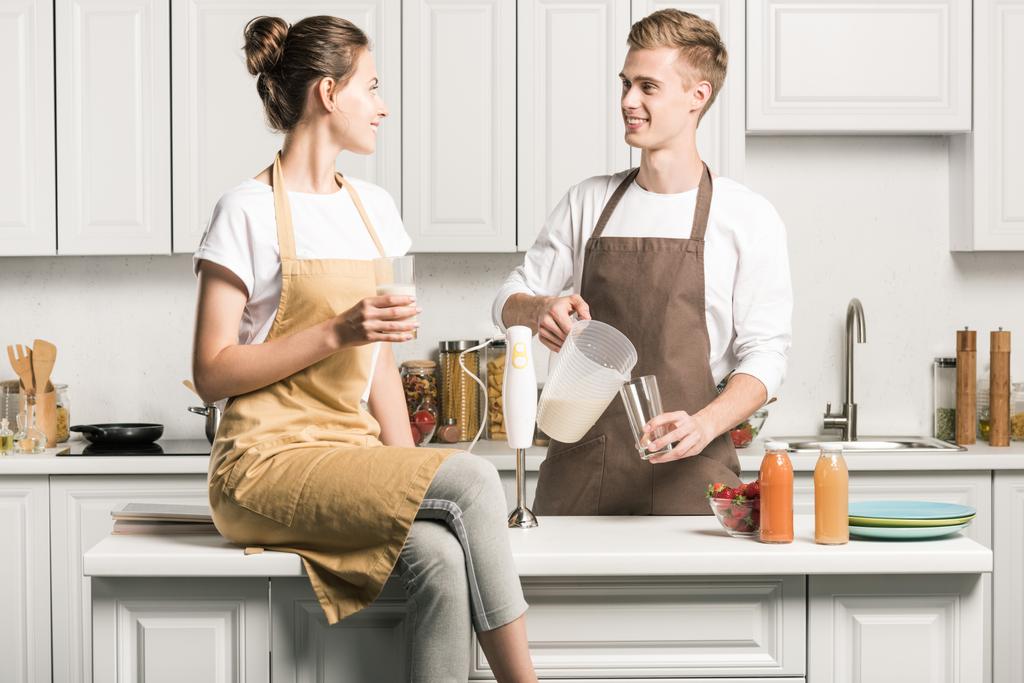 jovem casal derramando batido fresco na cozinha
 - Foto, Imagem