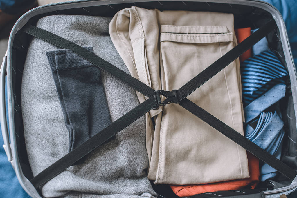 υπερυψωμένη θέα από τα ρούχα στη βαλίτσα ταξιδιώτη  - Φωτογραφία, εικόνα