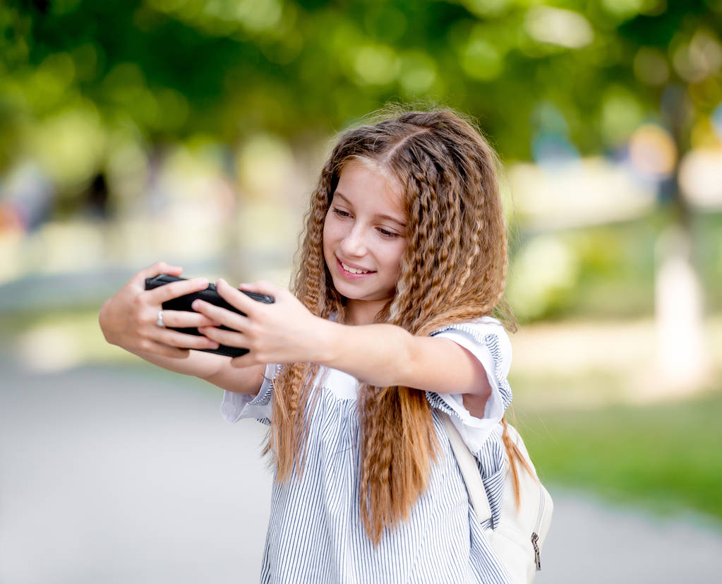 Ładna dziewczyna kręcone nastolatek sprawia, że selfie - Zdjęcie, obraz