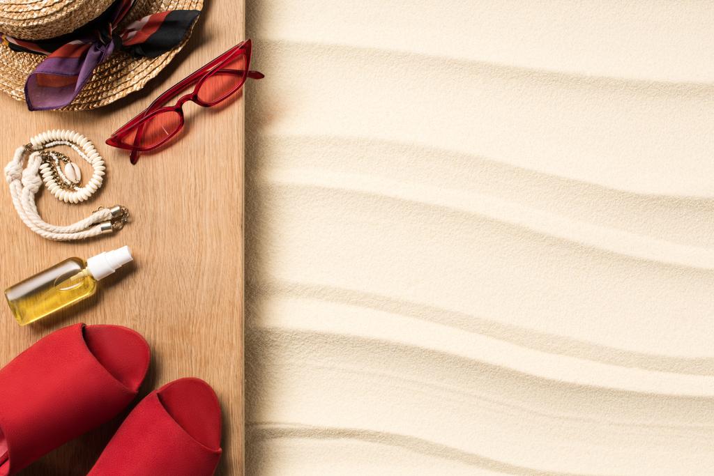 tendido plano con accesorios rojos femeninos para descansar en la playa sobre arena
 - Foto, Imagen