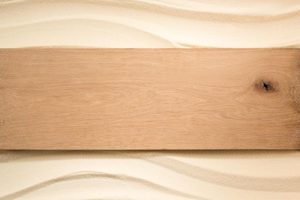 pohled shora na prázdné dřevěné prkno na písčitém povrchu - Fotografie, Obrázek