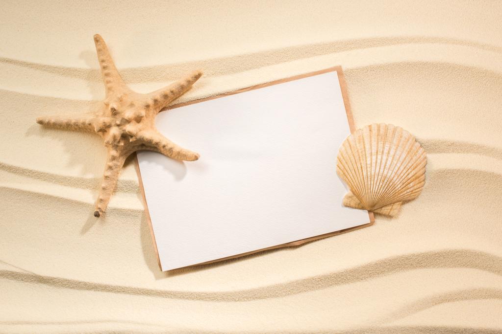 flat lay with sea star, seashell and blank paper on sand - Photo, Image