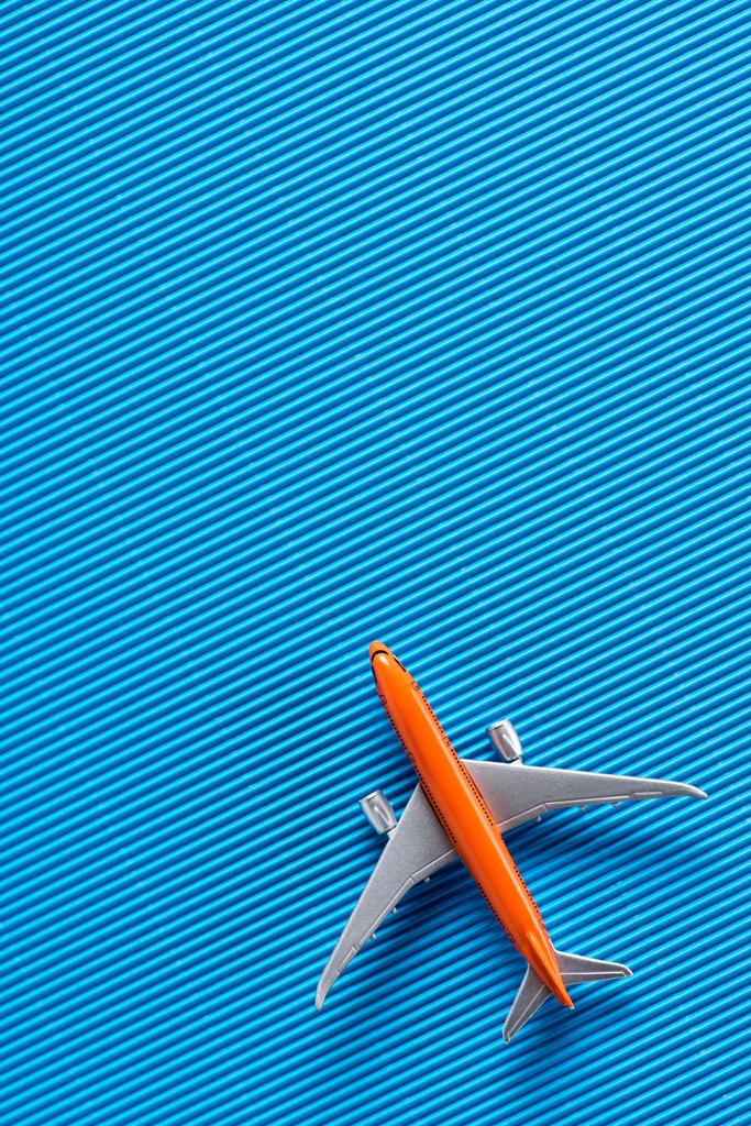 青い背景に、旅行のコンセプトにおもちゃの飛行機の上から見る - 写真・画像