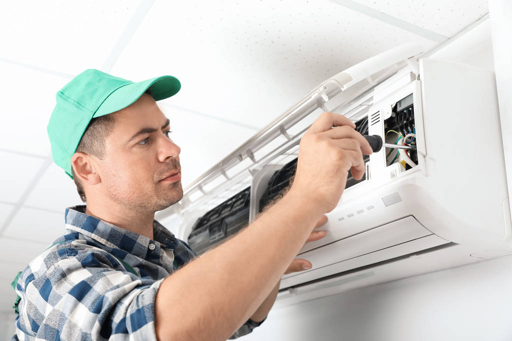 Técnico masculino reparando ar ar condicionado dentro de casa
 - Foto, Imagem