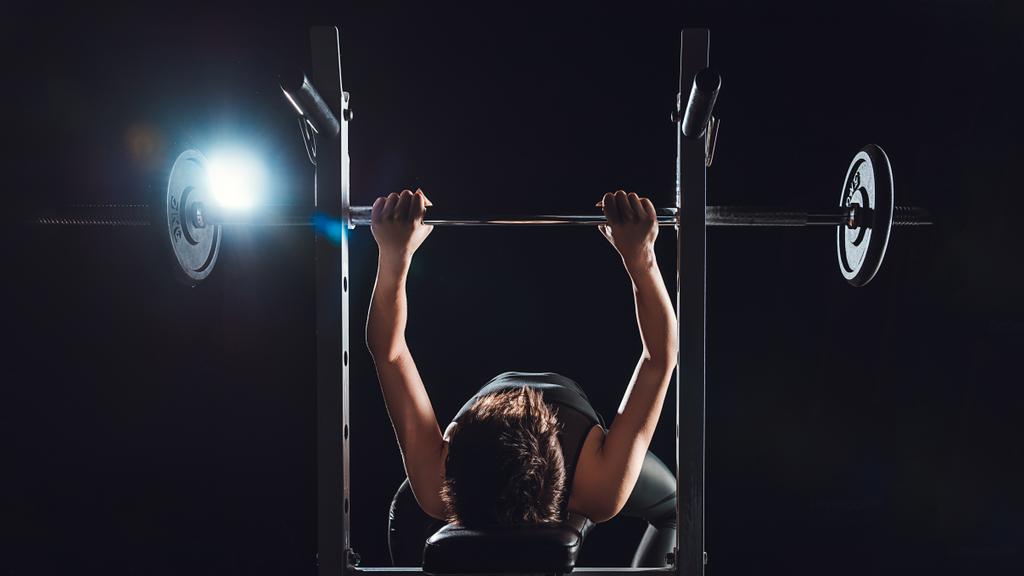 kadın vücut geliştirmeci halter, spor salonu, siyah arka plan ile egzersiz - Fotoğraf, Görsel