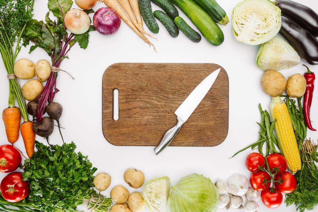 tendido plano con verduras maduras de otoño y tabla de cortar de madera con cuchillo aislado en blanco
 - Foto, imagen