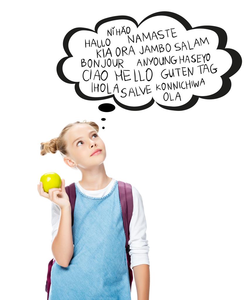 schoolchild holding apple and looking up at with words on different languages in speech bubble, isolated on white - Photo, Image