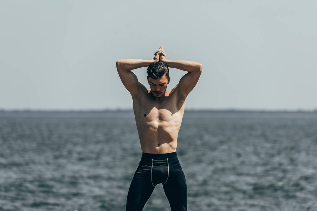schöner Mann ohne Hemd posiert vor Meerblick - Foto, Bild