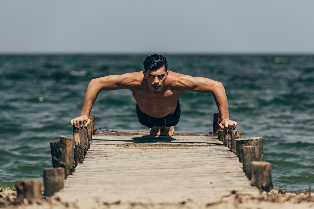 csinos sportos férfi során push up fából készült móló - Fotó, kép