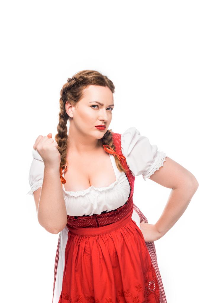 ernstige oktoberfest serveerster in traditionele Beierse jurk bedreigt door vuist geïsoleerd op witte achtergrond - Foto, afbeelding
