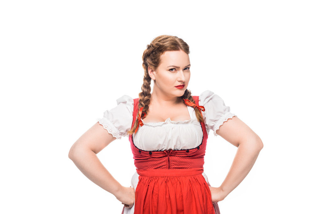 confiante garçonete oktoberfest em vestido tradicional bávaro de pé com as mãos na cintura isolada no fundo branco
 - Foto, Imagem
