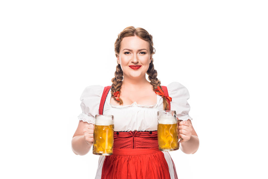 smiling oktoberfest waitress in traditional german dress with two mugs of light beer isolated on white background - Photo, Image
