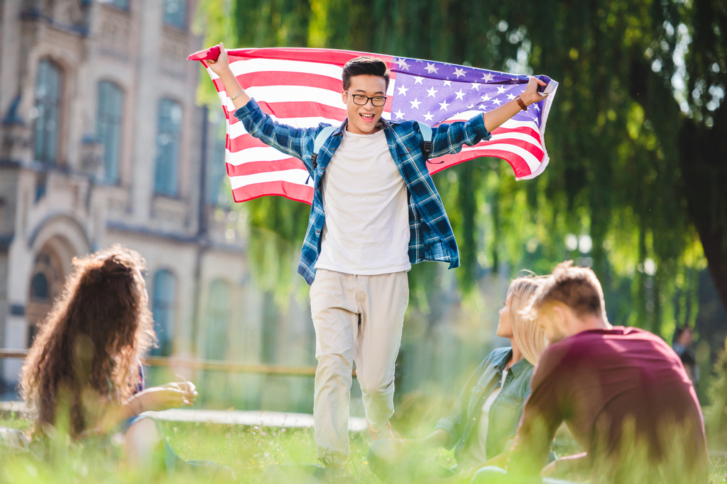 estudiantes multiculturales con bandera americana en el parque de verano
 - Foto, imagen