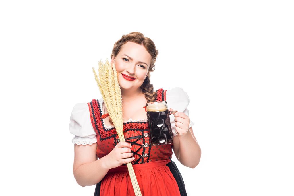 Lächelnde Oktoberfestkellnerin in bayerischer Tracht mit braunem Bierkrug und Weizenähren auf weißem Hintergrund - Foto, Bild