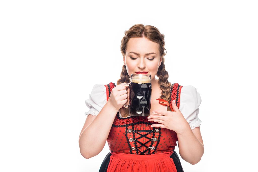 Октоберфест официантка в традиционном баварском платье, пьющая темное пиво на белом фоне
 - Фото, изображение