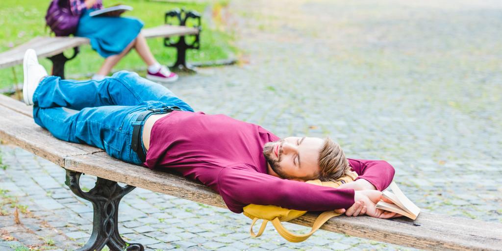 selective focus of student sleeping on wooden bench in park - Photo, Image