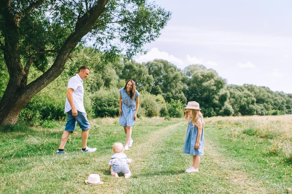 gelukkig gezin met twee kinderen samen tijd doorbrengen op zomer veld - Foto, afbeelding