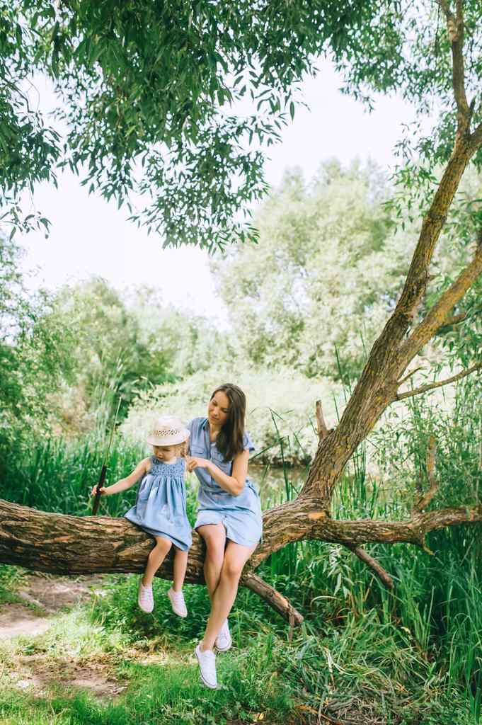 Stylový matka a dcera seděli na kmen stromu  - Fotografie, Obrázek