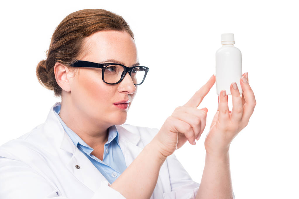 vertrouwen vrouwelijke arts in brillen wijzend op pil fles geïsoleerd op witte achtergrond  - Foto, afbeelding