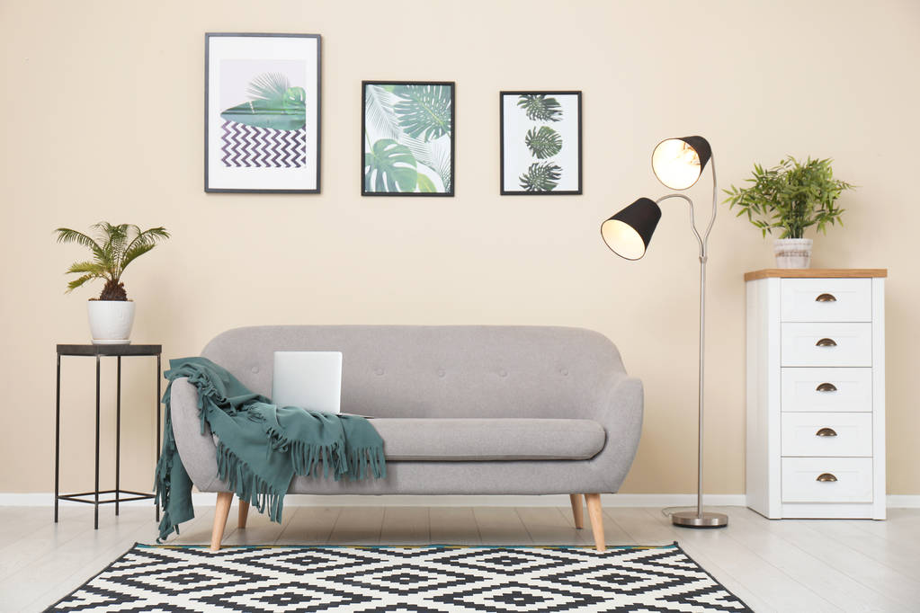 Стильний світлий інтер'єр кімнати зі зручним сірим диваном
 - Фото, зображення
