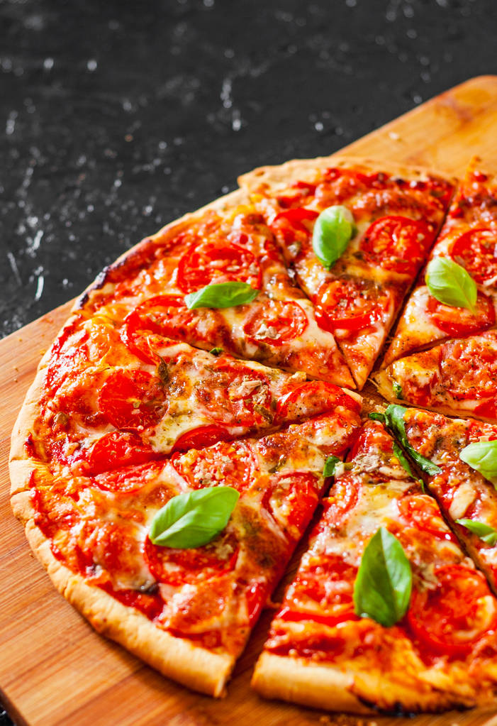 Pizza rebanada con queso Mozzarella, tomates, pimienta, especias y albahaca fresca. Pizza italiana. Pizza Margherita o Margarita
 - Foto, Imagen