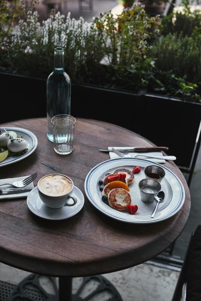 syrniki con café y ensalada en la mesa de madera en el restaurante
 - Foto, imagen