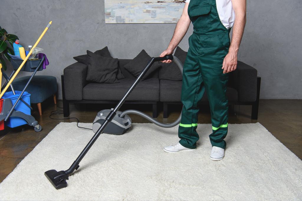 Oříznout záběr člověka pomocí vysavače a čistící bílý koberec - Fotografie, Obrázek