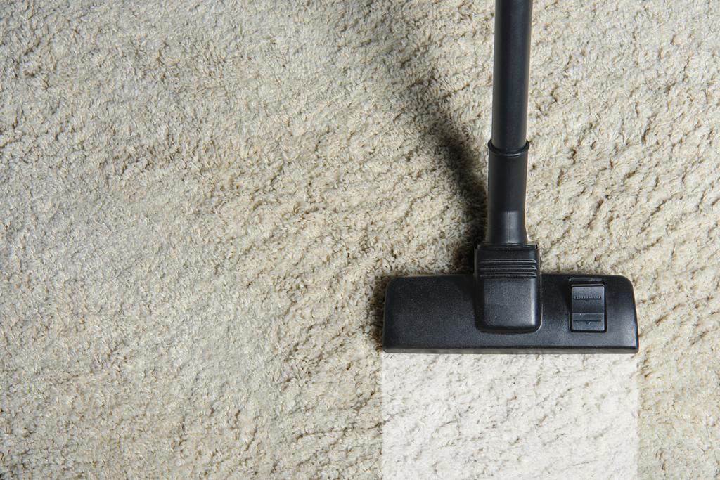 Ansicht der Reinigung des weißen Teppichs mit professionellem Staubsauger  - Foto, Bild
