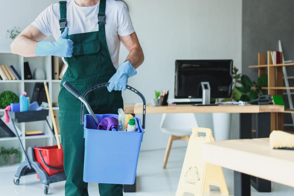cropped shot of professional cleaner holding bucket with cleaning supplies and showing thumb up - Photo, Image