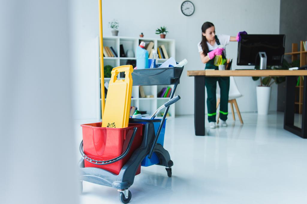 junge Hausmeisterinnen putzen Büro mit verschiedenen Reinigungsgeräten - Foto, Bild