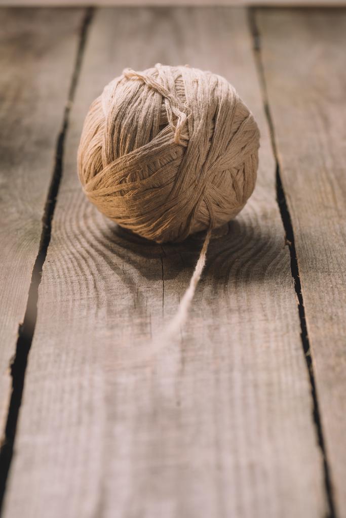 foco selectivo de bola de lana de punto beige sobre fondo de madera
  - Foto, Imagen