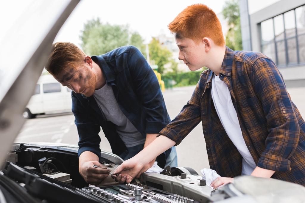 son giving tool for repairing car to father - Photo, Image