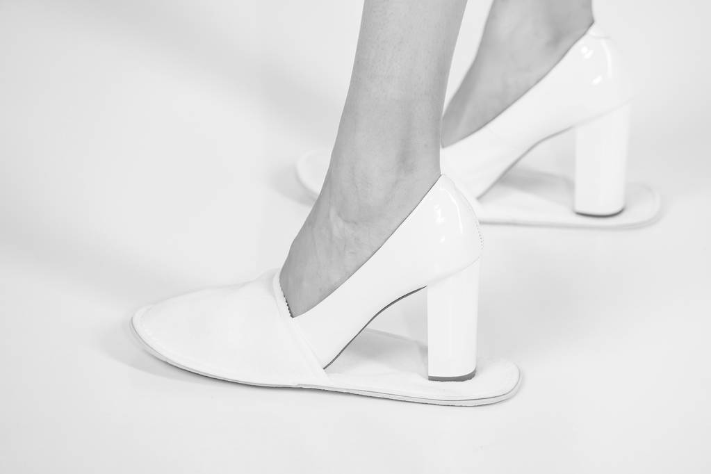 στα πόδια του κοριτσιού στο δέρμα μοντέρνα παπούτσια και παντόφλες - Φωτογραφία, εικόνα
