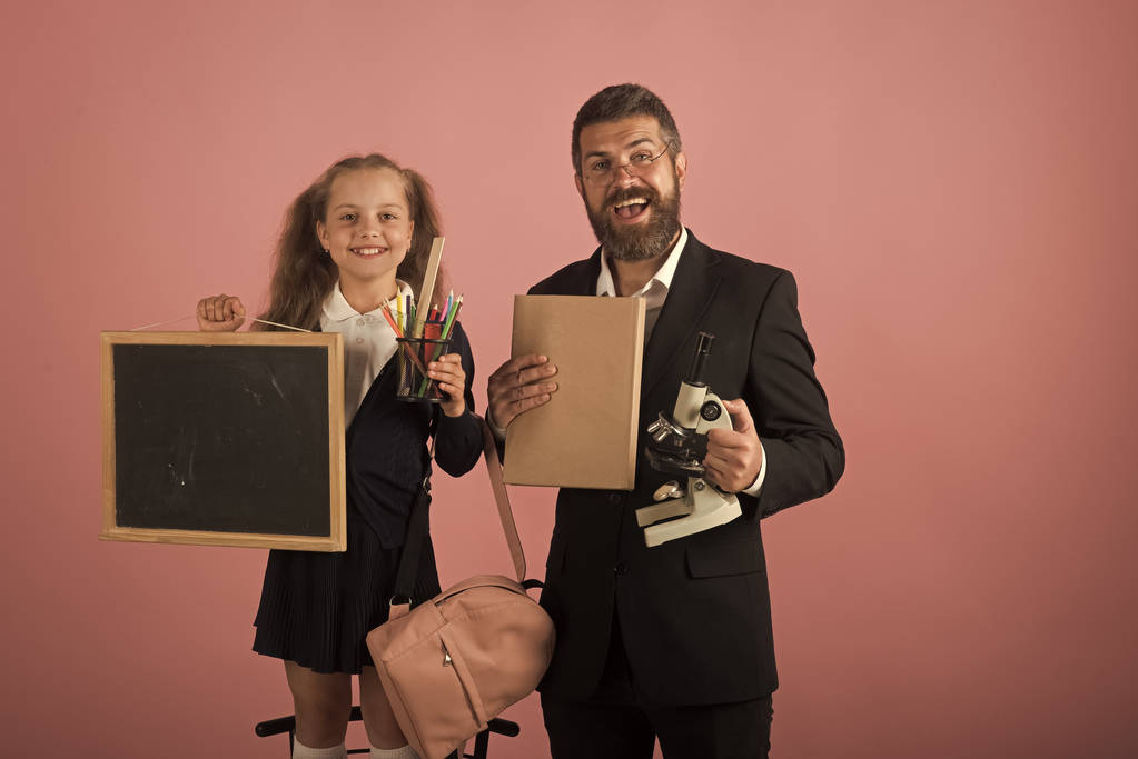 Vater und Schülerin mit glücklichen Gesichtern auf rosa Hintergrund - Foto, Bild