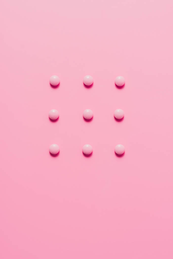 το Top view αποτελείται από ροζ χάπια σε ροζ επιφάνεια - Φωτογραφία, εικόνα
