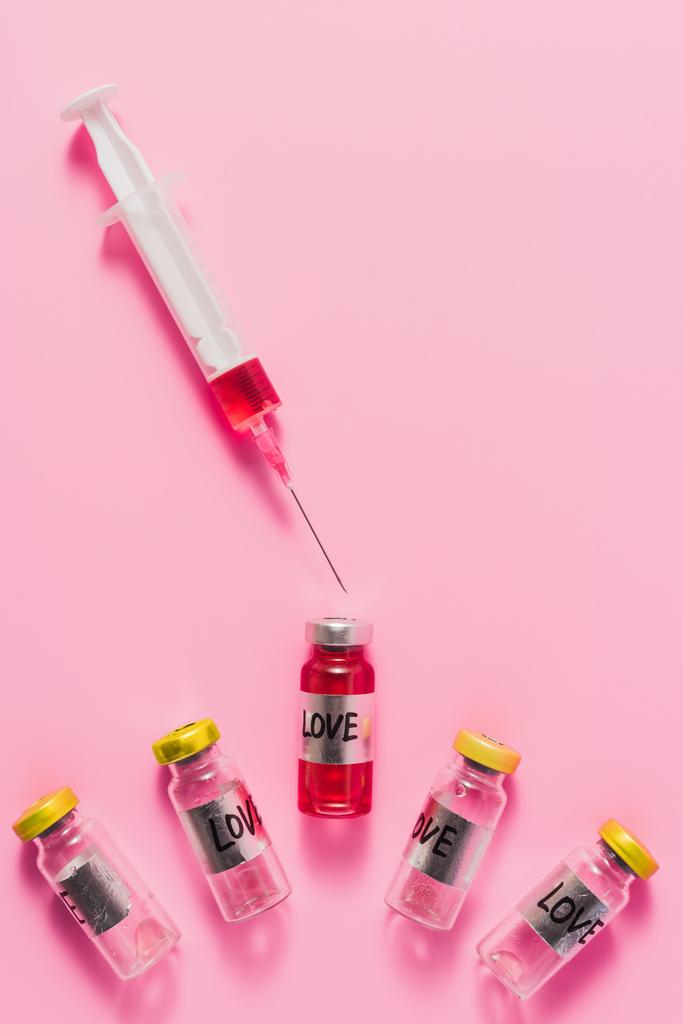 ピンクの注射器とワクチンの愛の印とボトルのトップ ビュー - 写真・画像