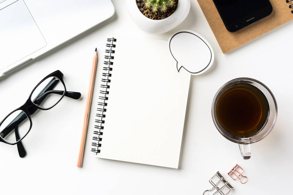 Businessconcept - bovenaanzicht van de witte achtergrond van het bureaublad met laptop, koffie, slimme telefoon, cactus en clip voor mockup ontwerp - Foto, afbeelding