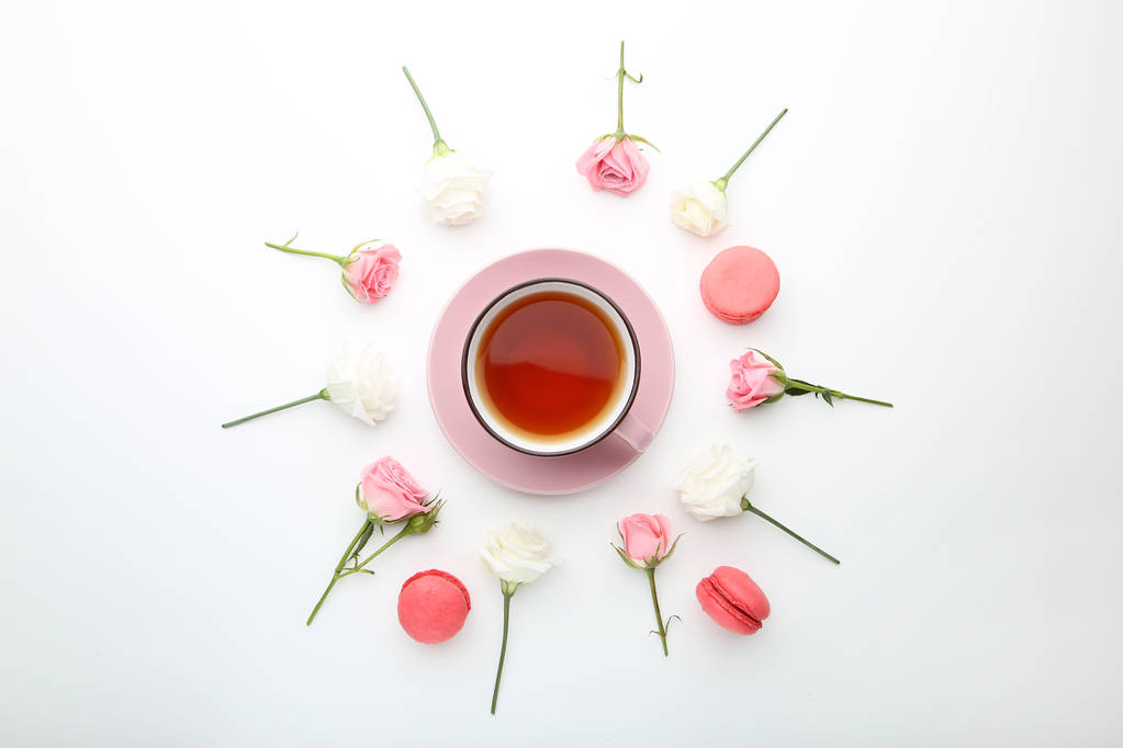 Rózsaszirom, csésze tea és macaroons fehér háttér - Fotó, kép