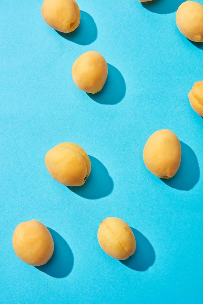 Draufsicht auf frische reife süße Aprikosen auf blauem Hintergrund - Foto, Bild