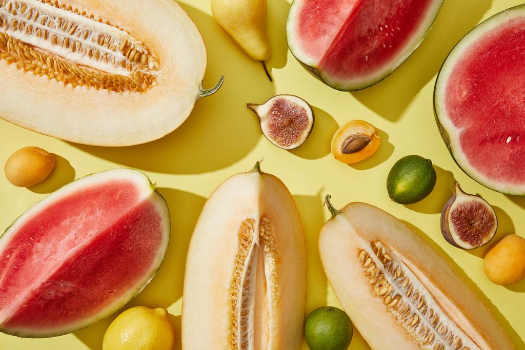 vista superior de melón fresco maduro, sandía, higo, pera, limas y albaricoques en amarillo
 - Foto, imagen