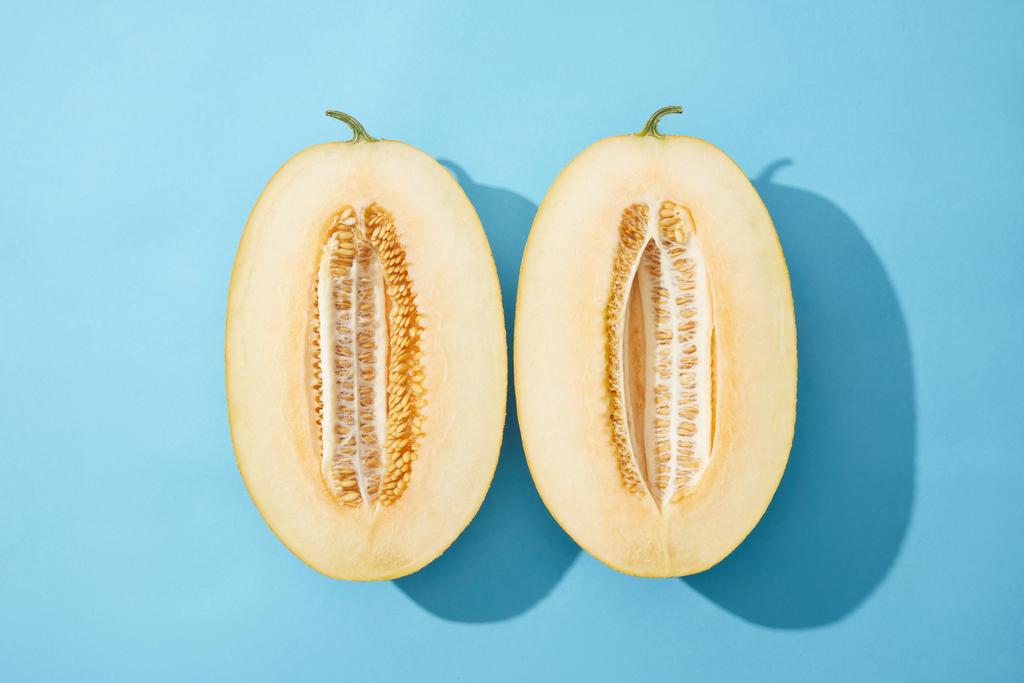 Draufsicht auf frische reife süße halbierte Melone auf blau - Foto, Bild
