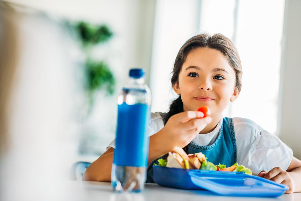 щаслива маленька школярка обідає в шкільних кафетеріях
 - Фото, зображення