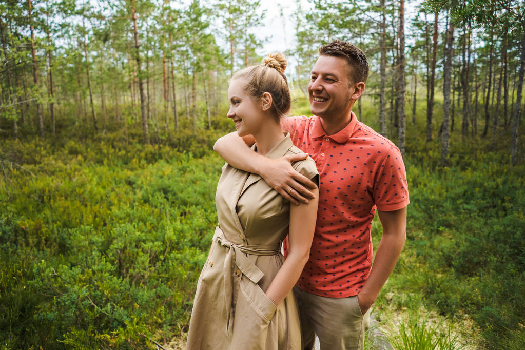 portrait of happy man hugging girlfriend with green plants on background - Photo, Image