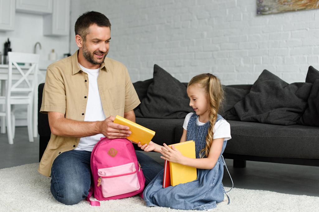 дочь и отец упаковки рюкзак для первого дня в школе, обратно к школьной концепции
 - Фото, изображение