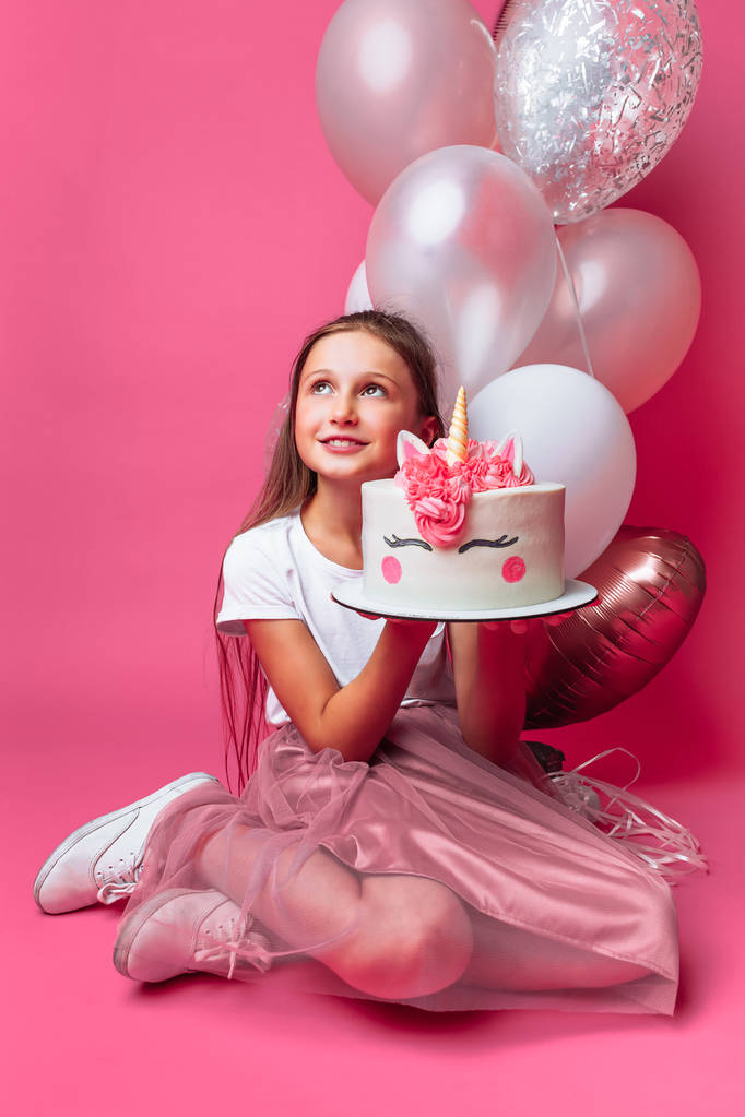 fille avec un gâteau pour un anniversaire, dans le studio sur un fond rose
 - Photo, image