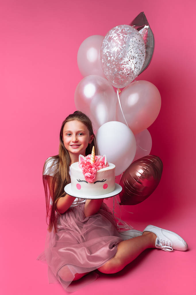 chica con un pastel para un cumpleaños, en el estudio sobre un fondo rosa
 - Foto, imagen