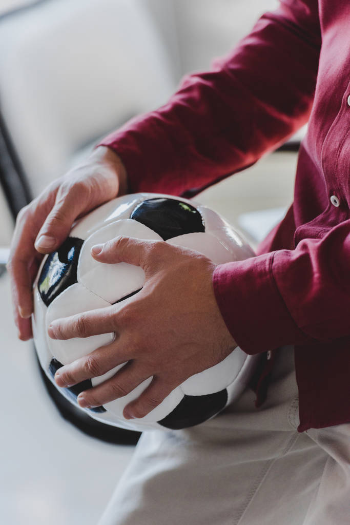 oříznuté záběr podnikatel drží fotbalový míč v úřadu - Fotografie, Obrázek